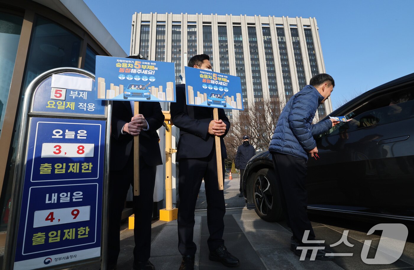 본문 이미지 - 25일 서울 종로구 정부서울청사 앞에서 청사 직원들이 원유 안보위기 ‘주의’ 경보 발령에 따른 공공 차량 5부제 캠페인을 벌이고 있다.  2026.3.25 ⓒ 뉴스1 임세영 기자