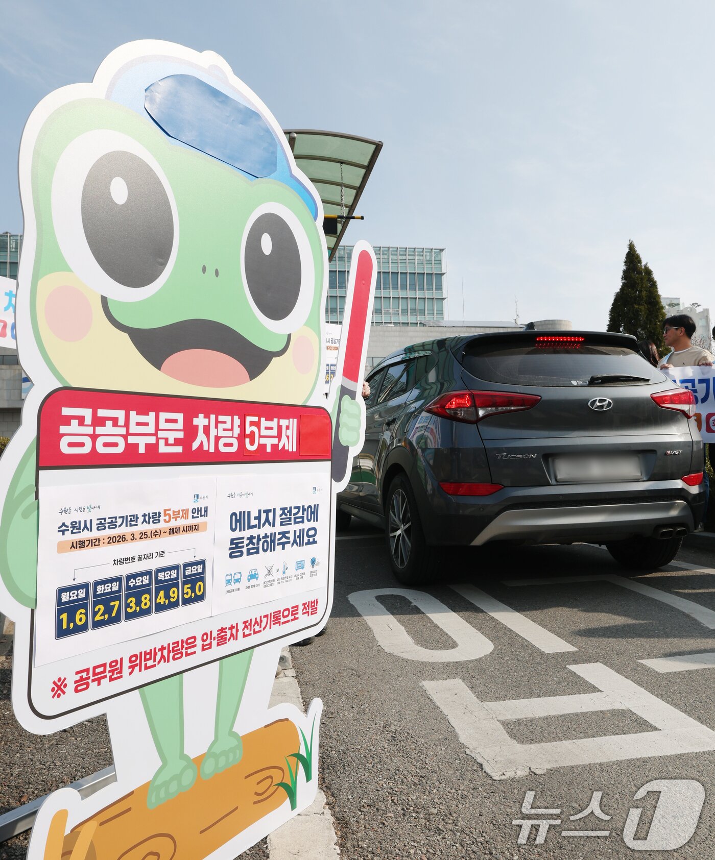 본문 이미지 - 25일 경기 수원시 팔달구 수원시청에서 직원들이 차량 5부제 참여 캠페인을 하고 있다. 2026.3.25 ⓒ 뉴스1 김영운 기자