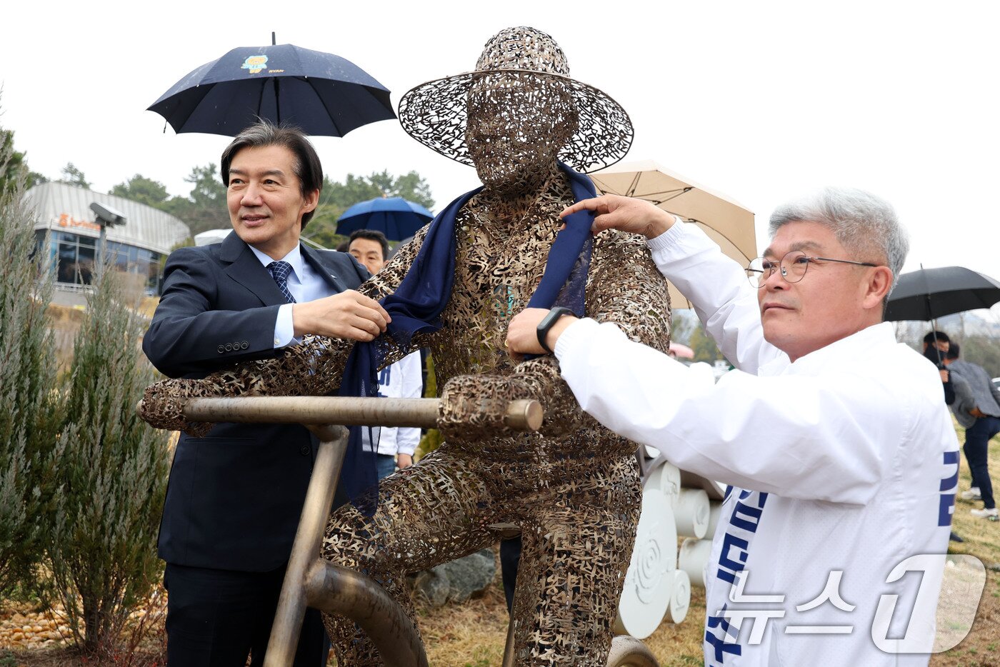 본문 이미지 - 조국 조국혁신당 대표가 25일 전남 나주시 빛가람동 호수공원을 찾아 노무현 전 대통령 조형물에 스카프를 걸고 있다. 2026.3.25 ⓒ 뉴스1 이승현 기자