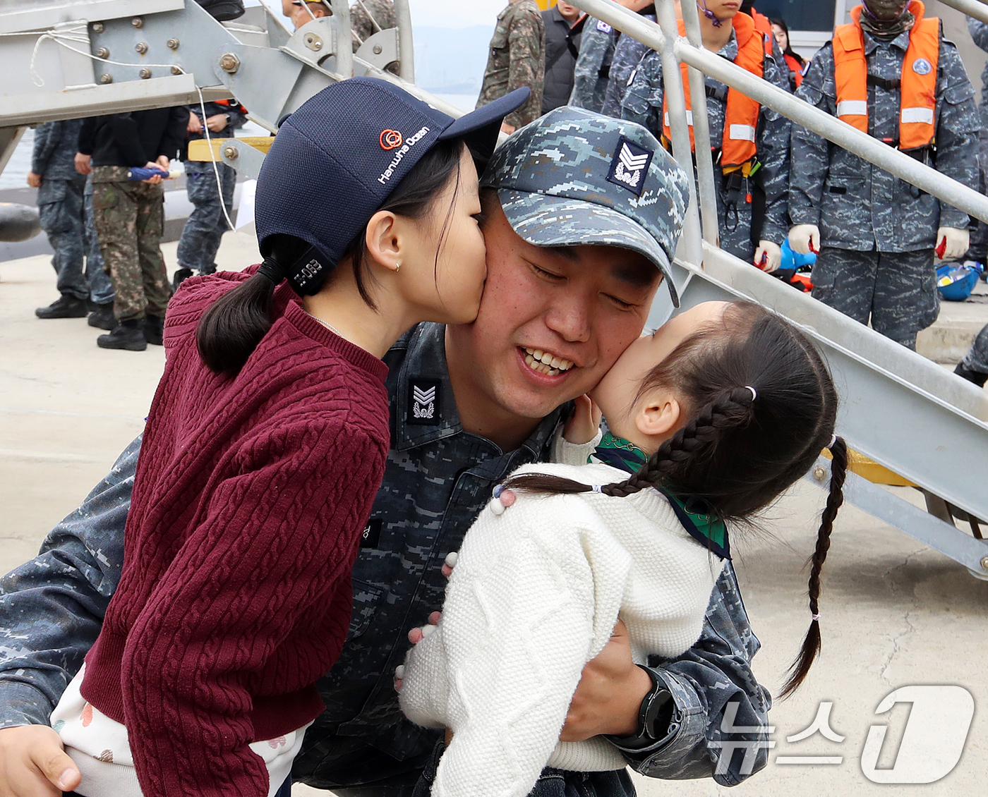 (창원=뉴스1) 윤일지 기자 = 25일 경남 창원 진해구 해군잠수함사령부에서 열린 도산안창호함 한국·캐나다 해군 연합협력훈련 환송행사에서 도산안창호함 승조원이 딸들에게 뽀뽀를 받고 …