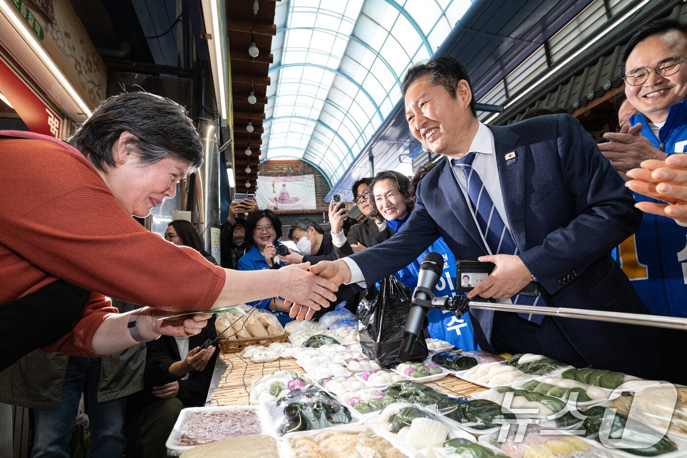 본문 이미지 - 정청래 더불어민주당 대표가 25일 충북 충주시 자유시장을 찾아 상인들과 인사하고 있다. 2026.3.25 ⓒ 뉴스1 이승배 기자