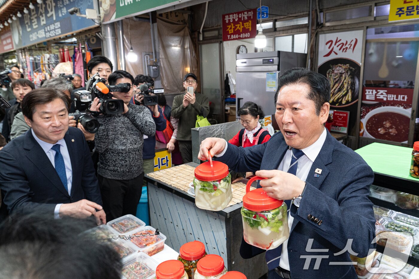 본문 이미지 - 정청래 더불어민주당 대표가 25일 충북 충주시 자유시장을 찾아 김치를 들어보이고 있다. 2026.3.25 ⓒ 뉴스1 이승배 기자