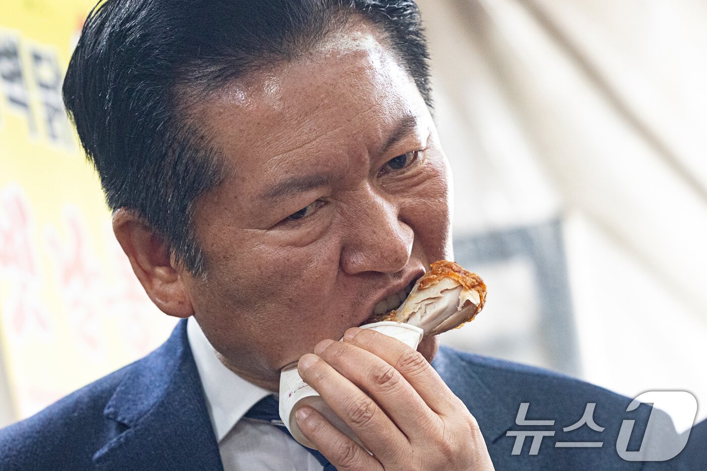 본문 이미지 - 정청래 더불어민주당 대표가 25일 충북 충주시 자유시장을 찾아 닭다리를 먹고 있다. 2026.3.25 ⓒ 뉴스1 이승배 기자