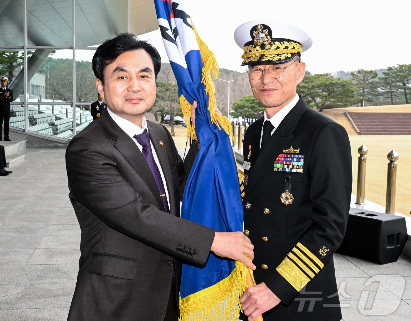 (서울=뉴스1) = 안규백 국방부 장관이 25일 오전 계룡대 대연병장에서 열린 제39대 해군참모총장 취임식에서 김경률 신임 해군 참모총장에게 해군기를 수여하고 있다. (해군 제공. …