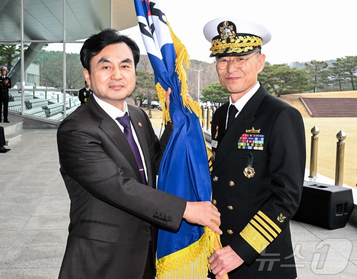 본문 이미지 - 안규백 국방부 장관이 25일 오전 계룡대 대연병장에서 열린 제39대 해군참모총장 취임식에서 김경률 신임 해군 참모총장에게 해군기를 수여하고 있다. (해군 제공. 재판매 및 DB 금지) 2026.3.25 ⓒ 뉴스1