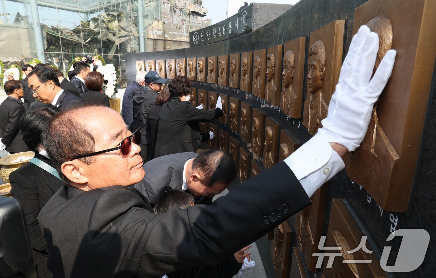 본문 이미지 - 26일 경기 평택시 해군 제2함대사령부에서 열린 '제16주기 천안함 46용사 추모식'에서 천안함 유가족들이 추모비를 어루만지고 있다. 2026.3.26 ⓒ 뉴스1 김영운 기자