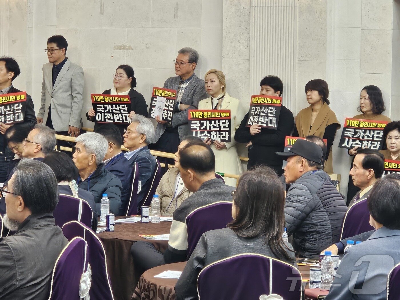 본문 이미지 - 용인시청 컨벤션홀에서 26일 열린 ‘용인 반도체 국가산단 사수 시민대책위원회’ 발대식에서 참석자들이 '쿡가산단 이전반대' 등이 적인 피켓을 들고 반도체 국가산단의 원안 추진을 촉구하고 있다. ⓒ 뉴스1 김평석 기자