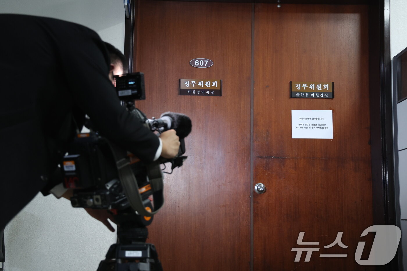 본문 이미지 - 2차 종합특검팀이 윤석열 정부 당시 대통령 관저 이전 특혜 의혹과 관련 국회 정무위원장실을 압수수색 중인 것으로 알려진 26일 서울 여의도 국회 윤한홍 정무위원회 위원장실 앞에 취재진이 대기하고 있다. 2026.3.26 ⓒ 뉴스1 안은나 기자