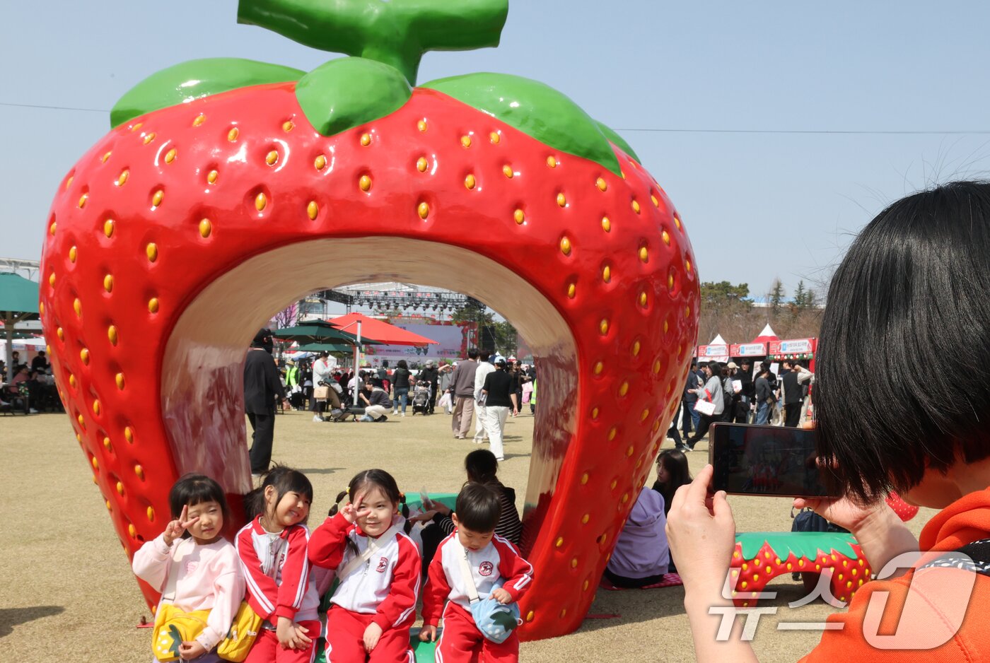 본문 이미지 - 충남 논산 딸기축제가 개막한 26일 논산시민가족공원 행사장에서 딸기 조형물앞에서 아이들이 포즈를 취하고 있다. 2026.3.26 ⓒ 뉴스1 김기태 기자