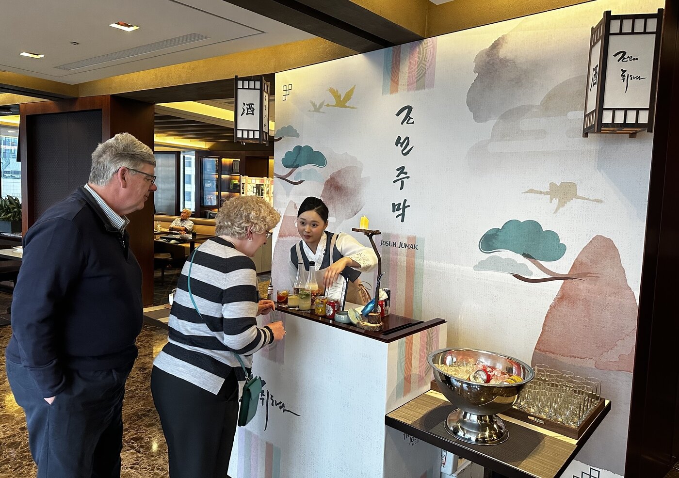본문 이미지 - 크리스틴 랭거스 씨가 엽전을 내고 막걸리 칵테일을 주문하고 있다.(조선호텔앤리조트 제공)