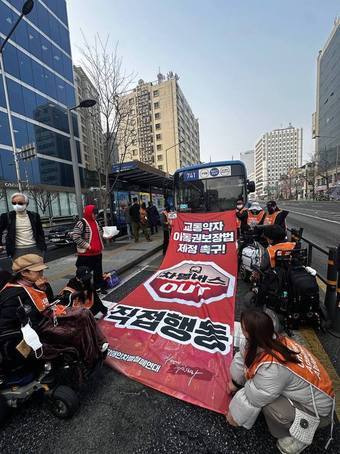 본문 이미지 - 전국장애인차별철폐연대가 27일 서울 광화문 일대에서 버스 탑승 시위를 진행하는 모습(전장연 제공)
