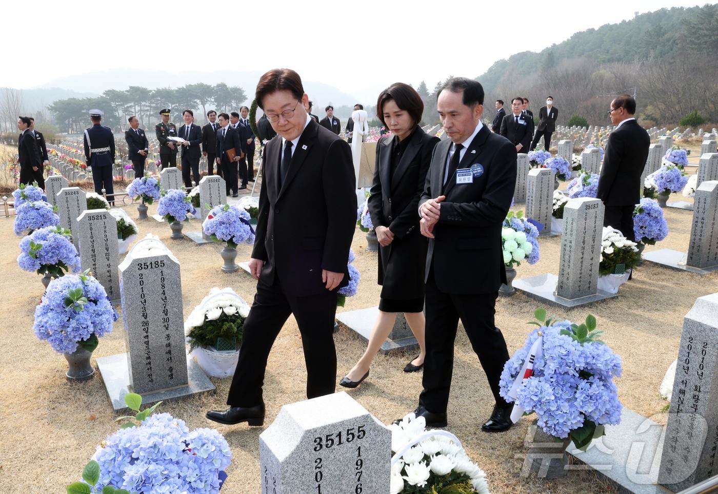 (대전=뉴스1) 허경 기자 = 이재명 대통령과 김혜경 여사가 27일 대전 국립대전현충원 천안함 용사 묘역을 최원일 전 천안함 함장과 돌아보고 있다. 2026.3.27/뉴스1