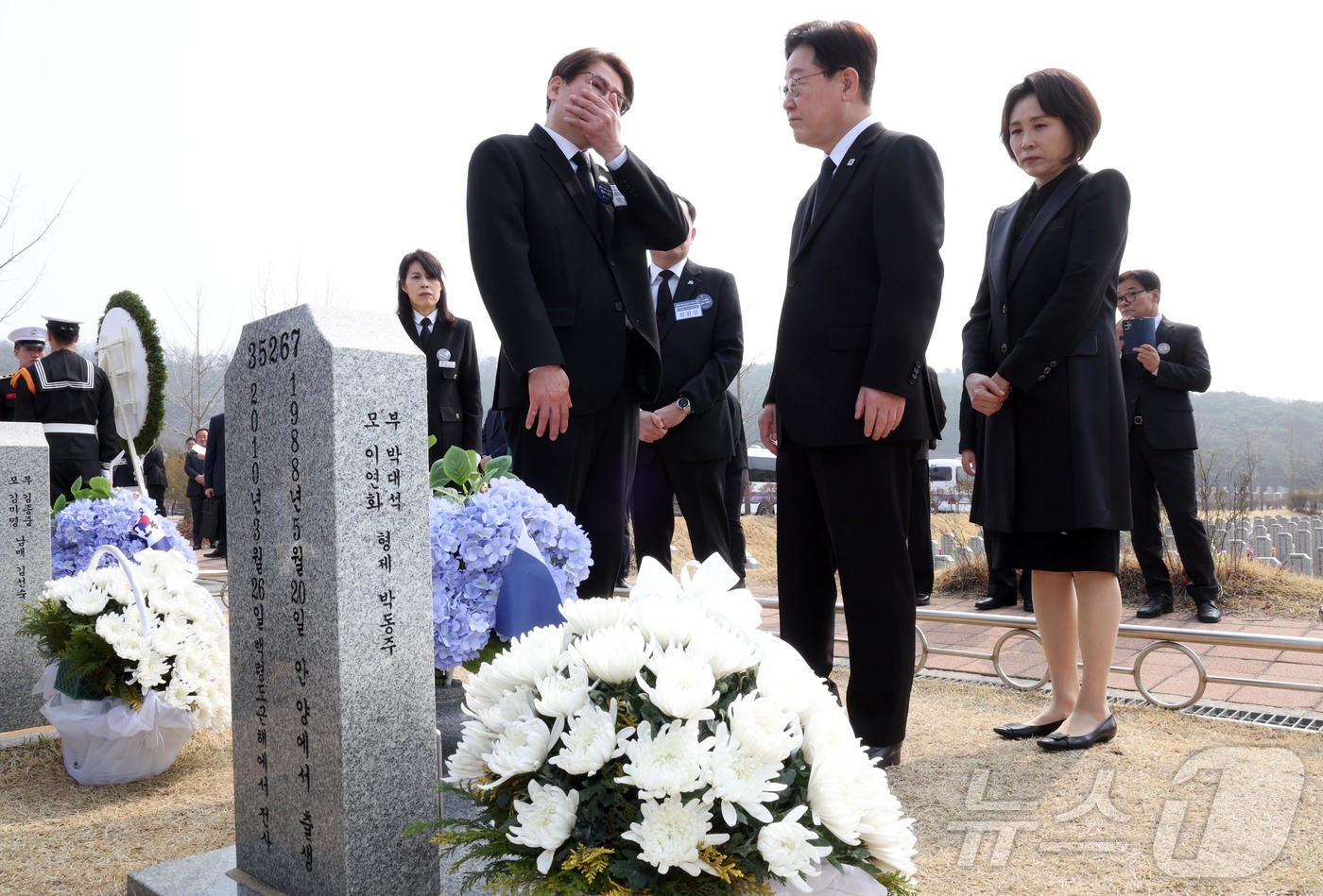 (대전=뉴스1) 허경 기자 = 이재명 대통령과 김혜경 여사가 27일 대전 국립대전현충원 천안함 용사 묘역에서 고 박정훈 병장의 묘비를 유가족과 살펴보고 있다. 2026.3.27/뉴 …