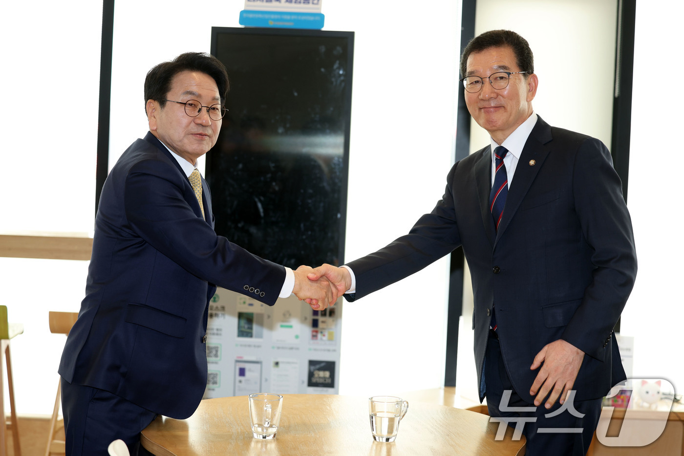 (목포=뉴스1) 이승현 기자 = 강기정(왼쪽), 신정훈 더불어민주당 전남광주통합특별시장 후보가 27일 전남 목포시 김대중노벨평화기념관에서 단일화 합의를 위해 만나 악수를 하고 있다 …