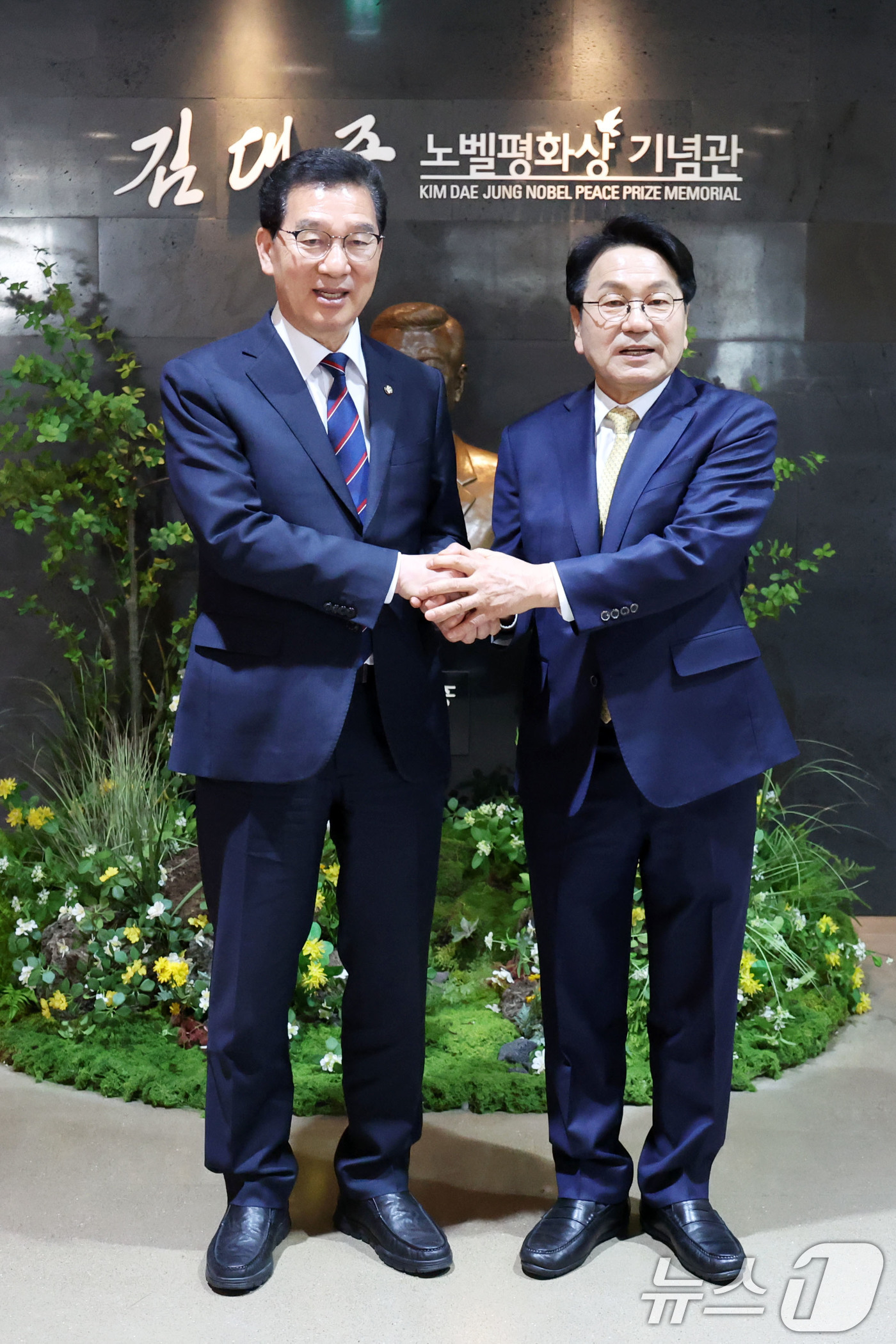 (목포=뉴스1) 이승현 기자 = 신정훈·강기정 더불어민주당 전남광주통합특별시장 후보가 27일 전남 목포시 김대중노벨평화기념관에서 단일화를 선언하고 악수를 하고 있다. 2026.3. …