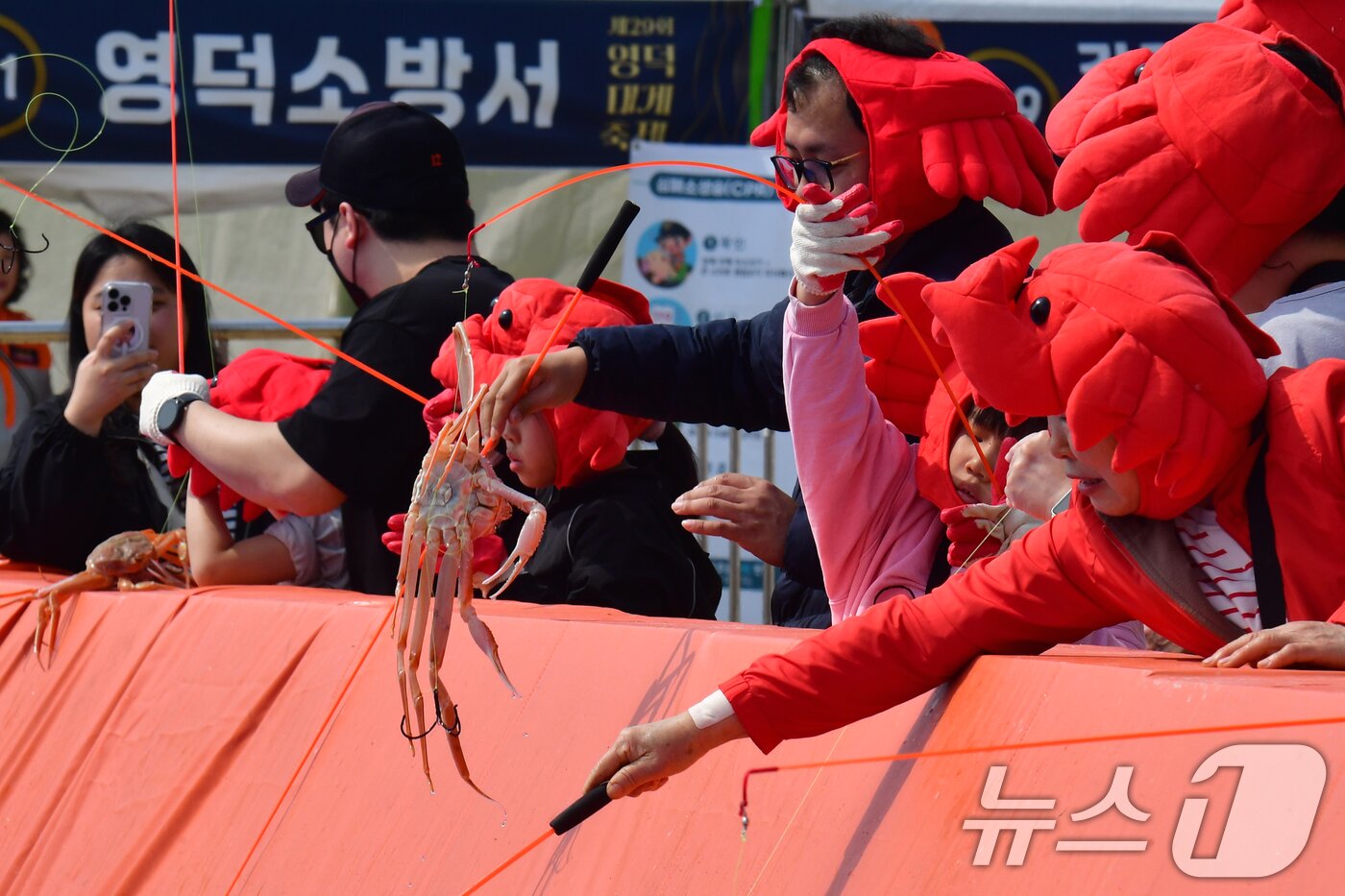 본문 이미지 - 29일 제29회 경북 영덕대게축제가 열린 강구항 해파랑공원에서 가족과 함께 온 어린이들이 대게낚시 체험을 하고 있다. 2026.3.29 ⓒ 뉴스1 최창호 기자