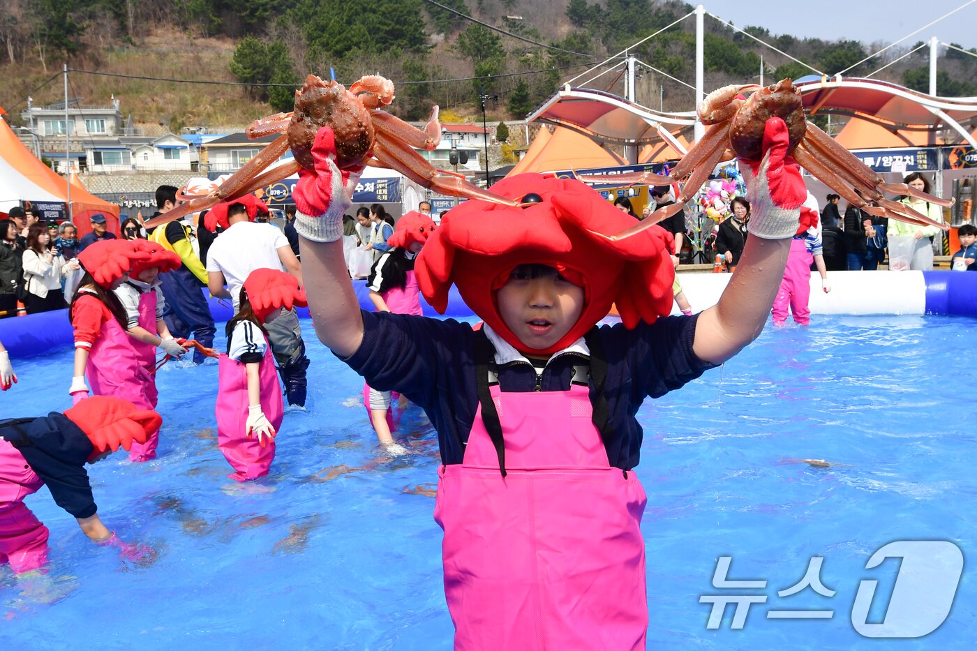 본문 이미지 - 29일 제29회 경북 영덕대게축제가 열린 강구항 해파랑공원에서 가족과 함께 온 어린이가 대게 맨손잡기 체험에서 잡은 대게를 자랑하고 있다. 2026.3.29 ⓒ 뉴스1 최창호 기자