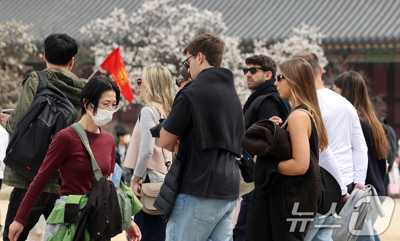 본문 이미지 - 포근한 날씨를 보인 29일 서울 종로구 경복궁을 찾은 외국인 관광객들이 겉옷을 몸에 두른 채 봄기운을 만끽하고 있다. 2026.3.29 ⓒ 뉴스1 박지혜 기자