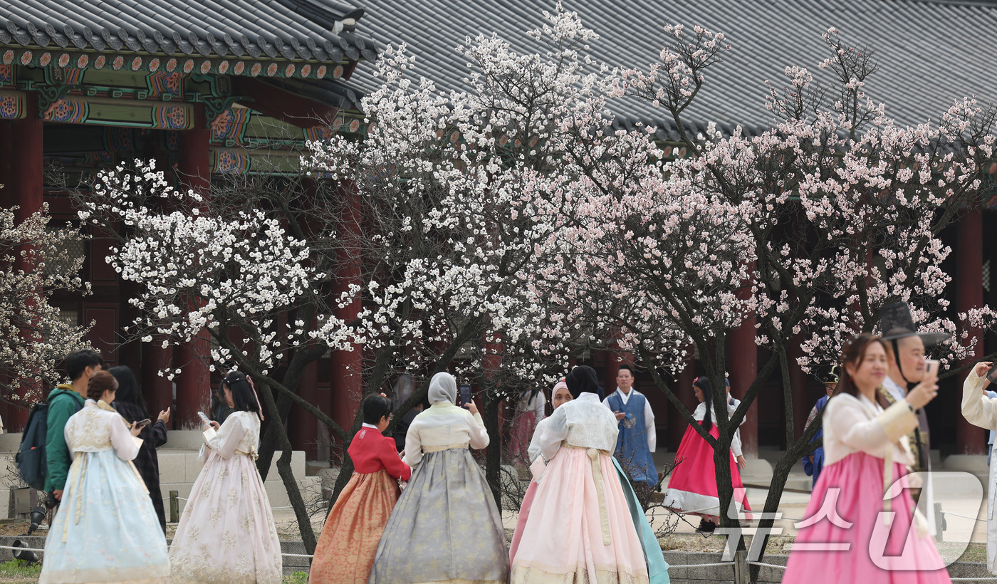 (서울=뉴스1) 박지혜 기자 = 포근한 날씨를 보인 29일 서울 종로구 경복궁을 찾은 외국인관광객들이 봄꽃을 배경으로 추억을 남기고 있다. 2026.3.29/뉴스1