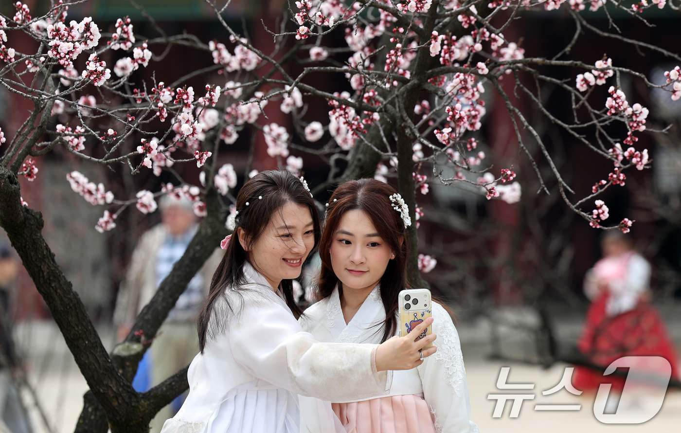 (서울=뉴스1) 박지혜 기자 = 포근한 날씨를 보인 29일 서울 종로구 경복궁을 찾은 외국인관광객들이 봄꽃을 배경으로 추억을 남기고 있다. 2026.3.29/뉴스1