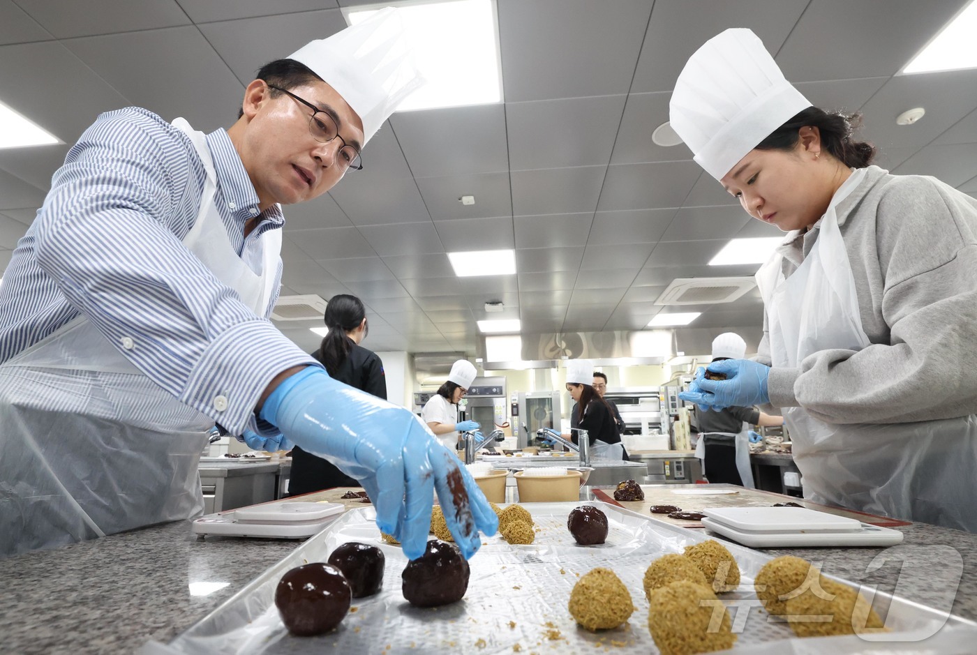 (대전=뉴스1) 김기태 기자 = 29일 대전 동구 우송정보대학에서 열린 ‘두쫀쿠 만들기 체험 행사’에 박희조 동구청장이 다자녀 맞벌이부부와 함께 참여해 제과제빵 실습을 하고 있다. …