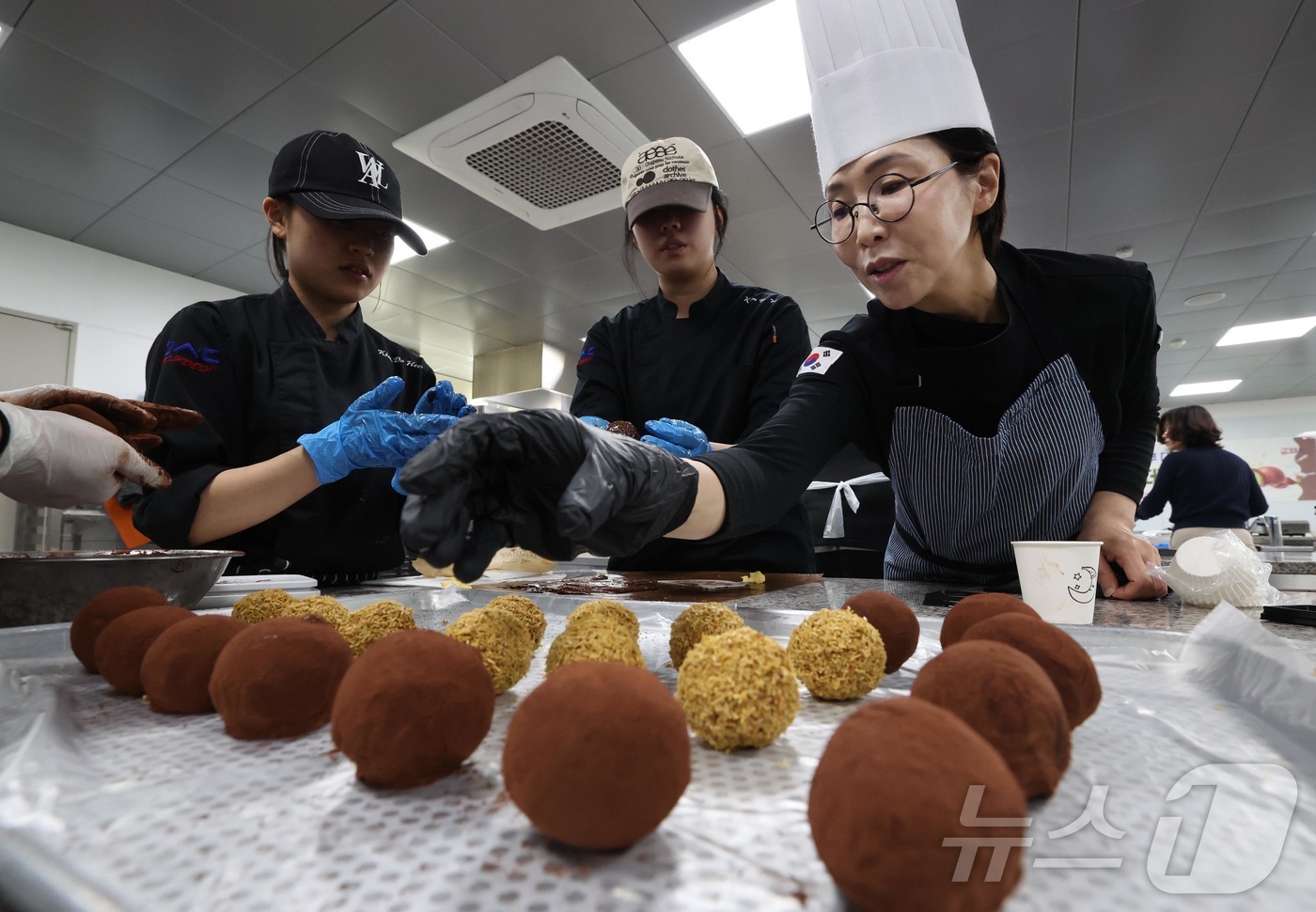 (대전=뉴스1) 김기태 기자 = 29일 대전 동구 우송정보대학에서 열린 ‘두쫀쿠 만들기 체험 행사’에 박희조 동구청장이 다자녀 맞벌이부부와 함께 참여해 제과제빵 실습을 하고 있다. …