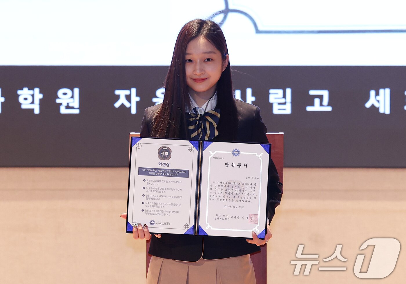 본문 이미지 - 2026 밀라노·코르티나 동계올림픽 피겨스케이팅에 출전한 신지아가 3일 서울 서초구 반포동 세화여자고등학교에서 열린 특별장학금 수여식에서 장학증서를 받은 후 기념촬영을 하고 있다. 2026.3.3 ⓒ 뉴스1 김성진 기자