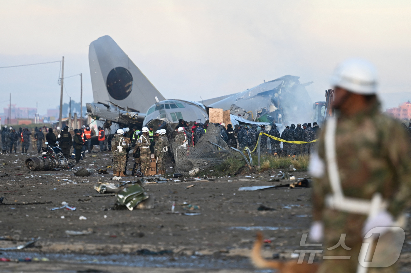 (엘알토 로이터=뉴스1) 양은하 기자 = 28일(현지시간) 볼리비아 엘알토에서 악천후 속에 볼리비아 공군 소속 허큘리스 항공기가 번화한 대로로 추락한 뒤 긴급 구조 요원들이 현장에 …