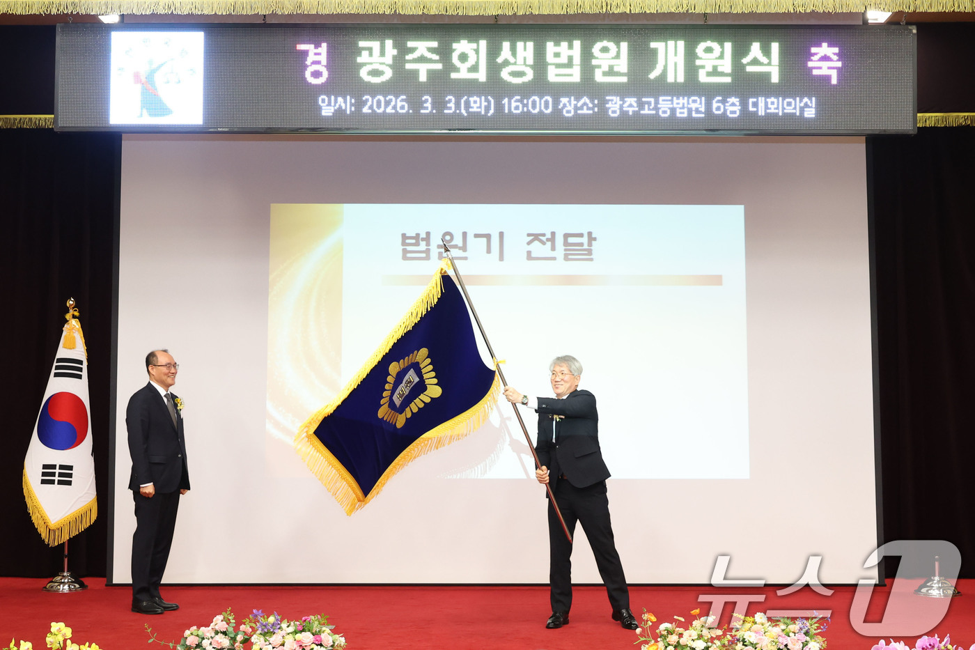 (광주=뉴스1) 이승현 기자 = 김성주 초대 광주회생법원장이 3일 오후 광주 동구 고등법원에서 열린 광주회생법원 개원식에서 전달받은 법원기를 흔들고 있다. 2026.3.3/뉴스1