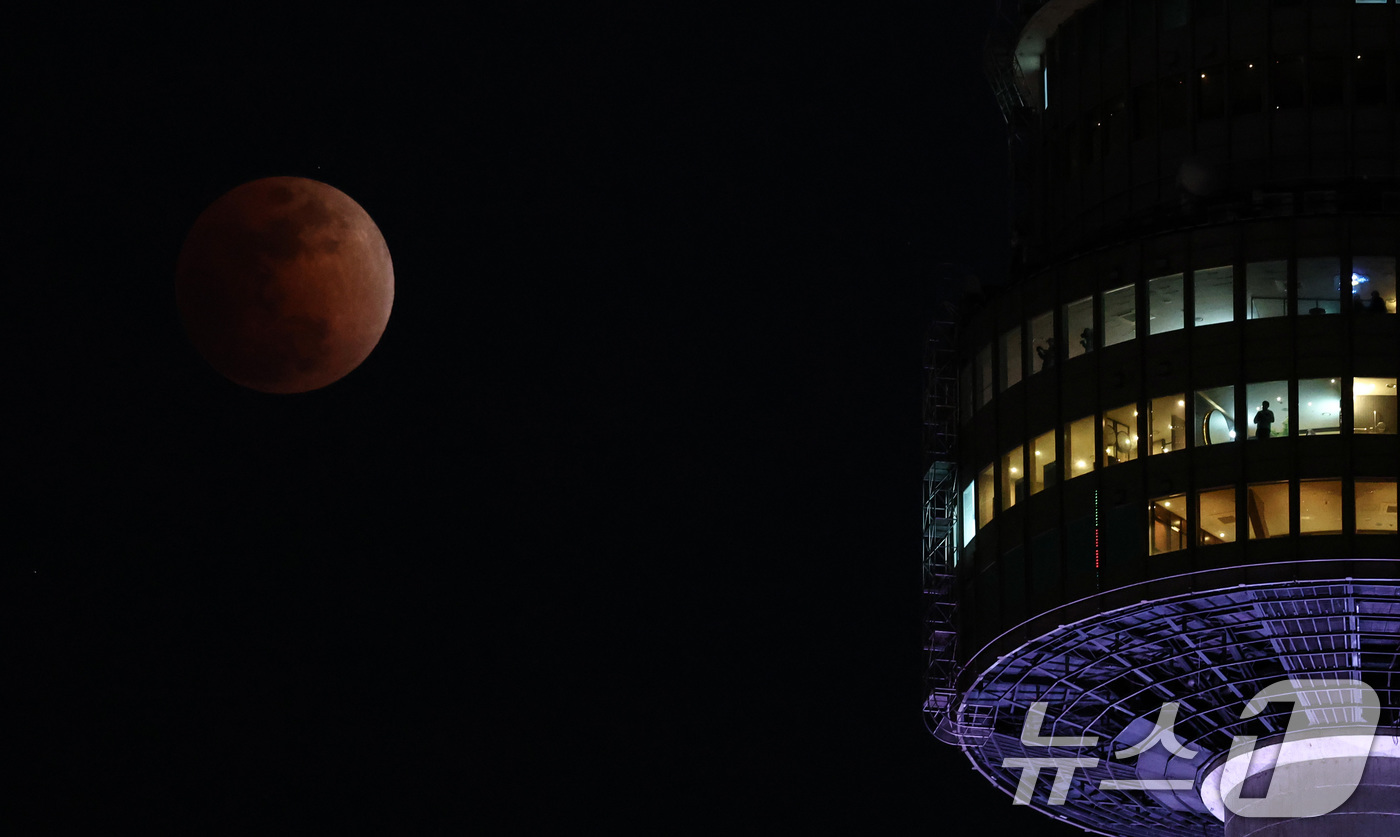 (서울=뉴스1) 최지환 기자 = 3일 밤 서울 상공에 떠오른 블러드문이 남산타워 뒤로 지나고 있다. 2026.3.3/뉴스1