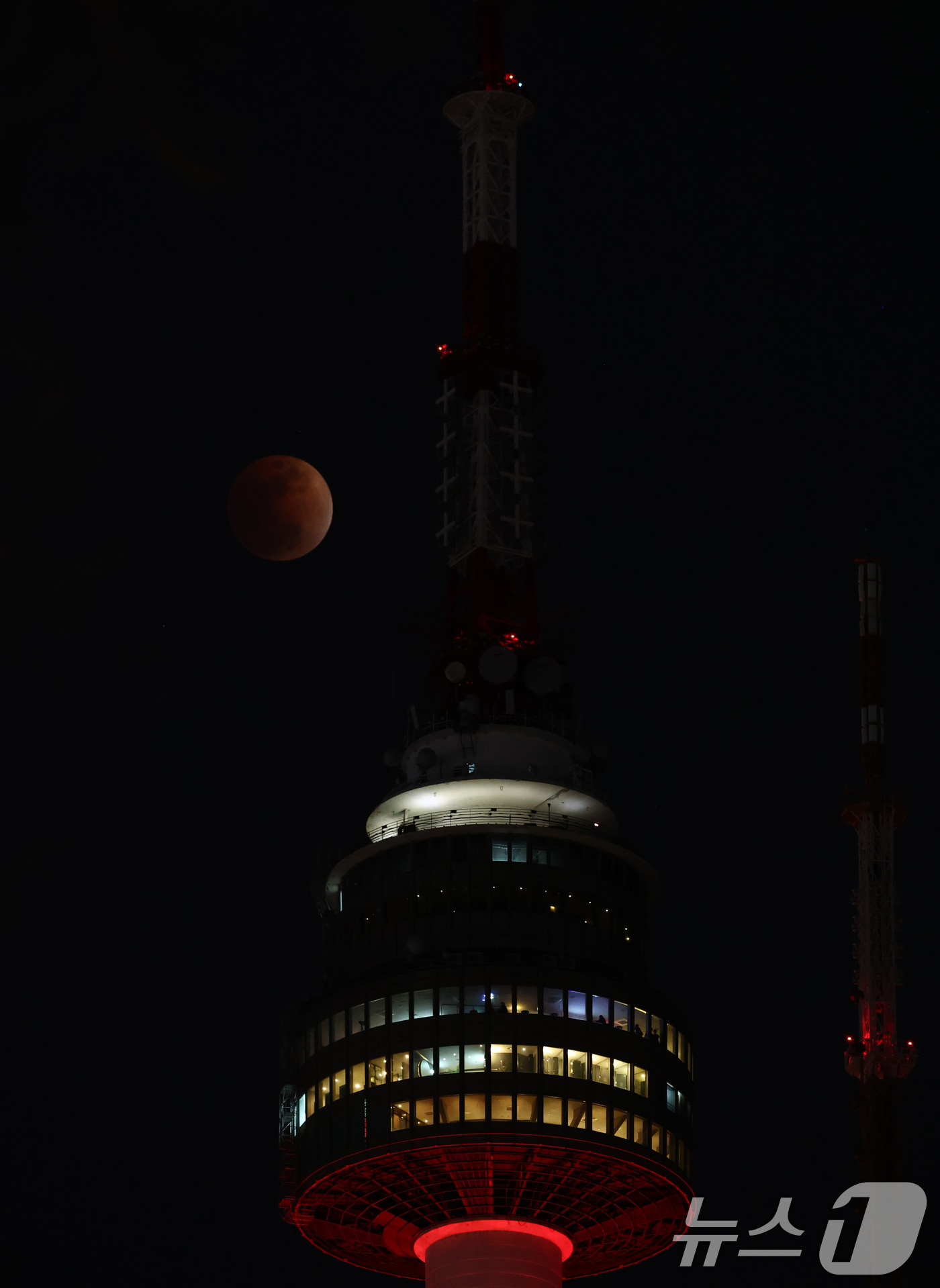 (서울=뉴스1) 최지환 기자 = 3일 밤 서울 상공에 떠오른 블러드문이 남산타워 뒤로 지나고 있다. 2026.3.3/뉴스1
