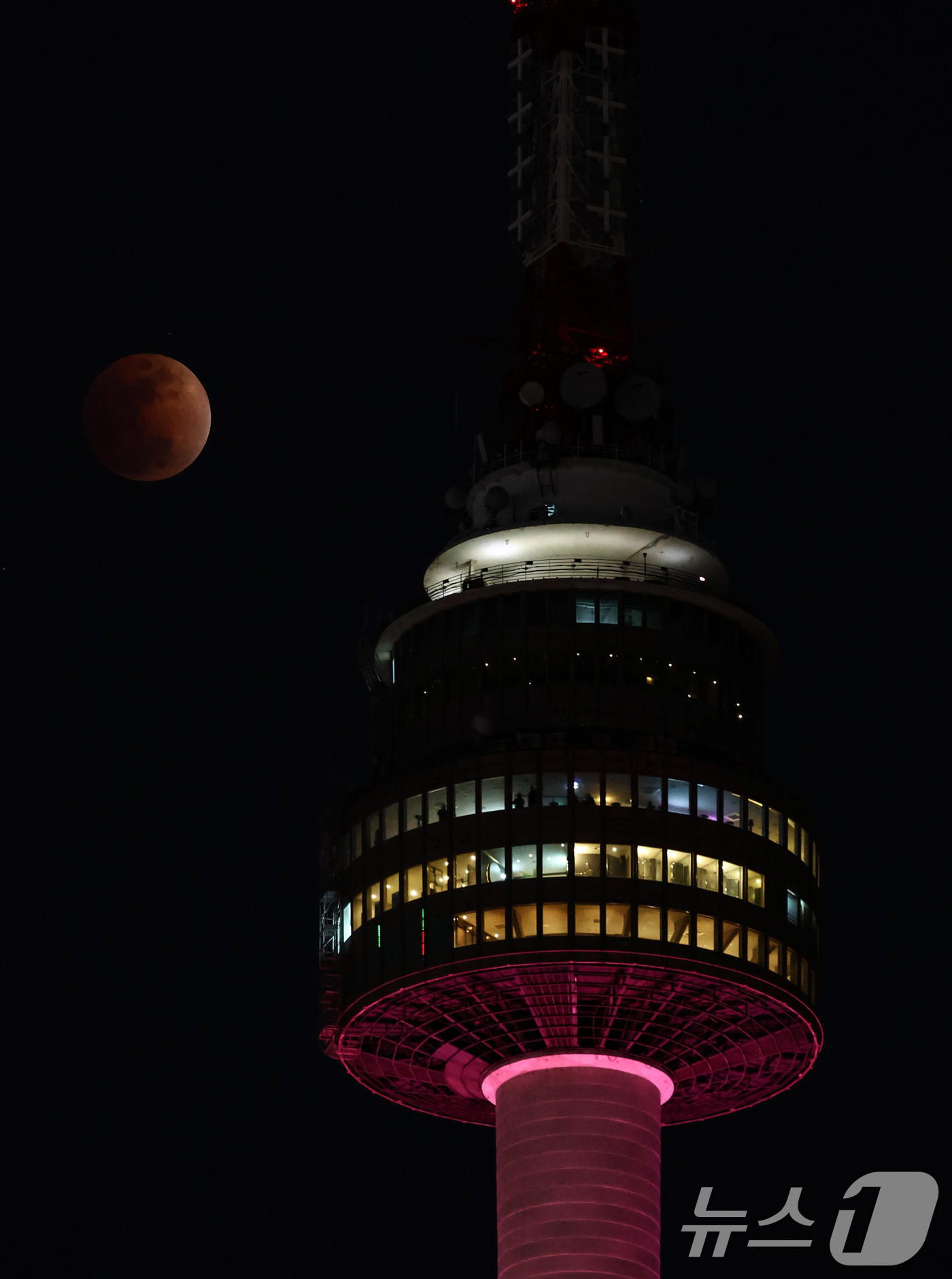 (서울=뉴스1) 최지환 기자 = 3일 밤 서울 상공에 떠오른 블러드문이 남산타워 뒤로 지나고 있다. 2026.3.3/뉴스1