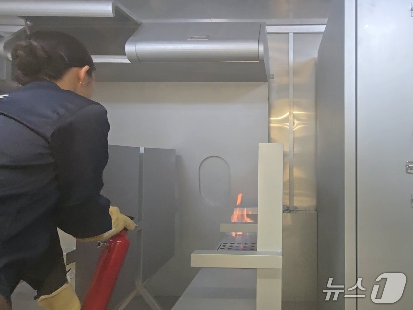 본문 이미지 - 27일 경기 부천 유한대학교에 문을 연 파라타항공 항공훈련센터 내 화재진압 실습실에서 파라타항공 승무원들이 기내 좌석 화재 상황을 가정해 소화기로 초동 진화에 나서고 있다. 2026.3.27/뉴스1 김성식 기자