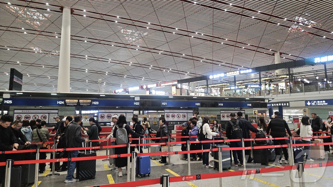 본문 이미지 - 30일 오전 중국 베이징 서우두공항 제3터미널에서 베이징~평양 노선을 포함한 주요 국제선 노선 탑승 수속 카운터에 사람들이 줄을 서 있다. ⓒ 뉴스1 정은지 특파원