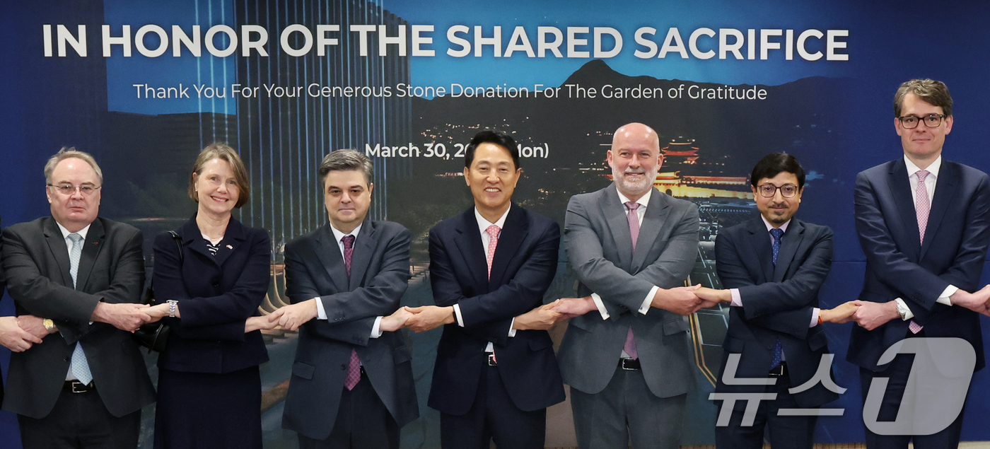 (서울=뉴스1) 황기선 기자 = 오세훈 서울시장이 30일 오후 서울시청에서 열린 '감사의 정원 석재 기증국 주한외교단 초청 간담회'에서 참석자들과 손을 맞잡고 기념촬영을 하고 있다 …