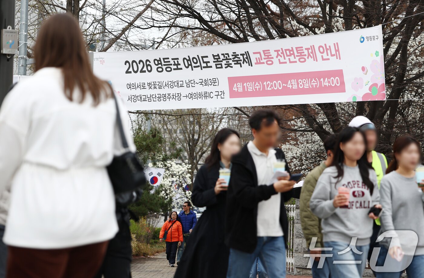 본문 이미지 - 31일 오후 서울 여의도 윤중로 벚꽃길 인근에 2026 여의도 봄꽃축제 교통 전면통제 안내 현수막이 걸려 있다. 2026.3.31 ⓒ 뉴스1 김민지 기자