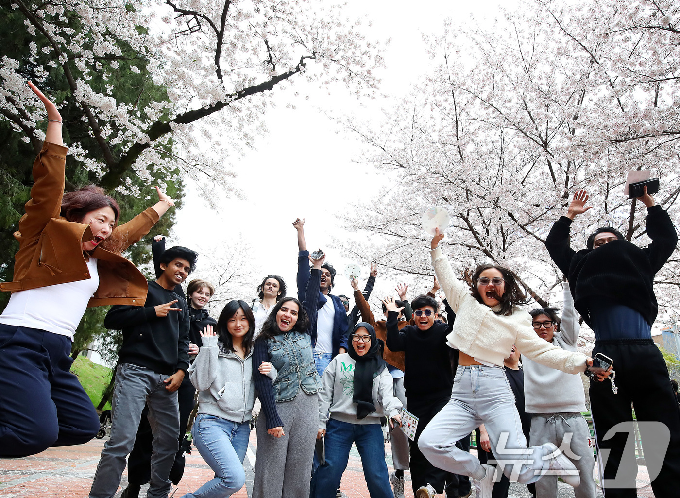 (대구=뉴스1) 공정식 기자 = 31일 대구 북구 경북대학교에서 열린 '개교 80주년 기념 벚꽃 거리 축제'를 찾은 외국인 유학생들이 일청담 주변에 활짝 핀 벚꽃을 배경으로 기념촬 …