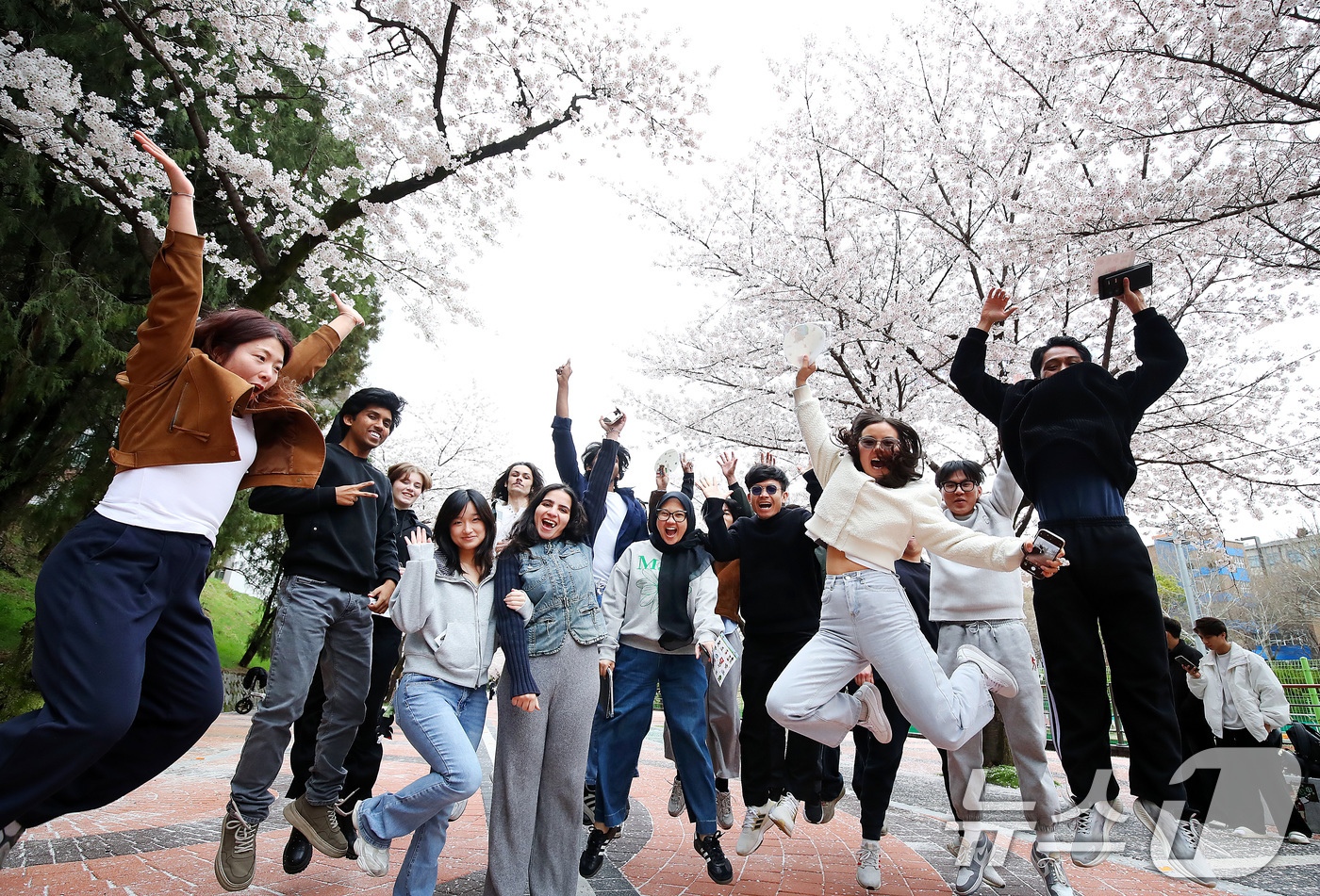 (대구=뉴스1) 공정식 기자 = 31일 대구 북구 경북대학교에서 열린 '개교 80주년 기념 벚꽃 거리 축제'를 찾은 외국인 유학생들이 일청담 주변에 활짝 핀 벚꽃을 배경으로 기념촬 …