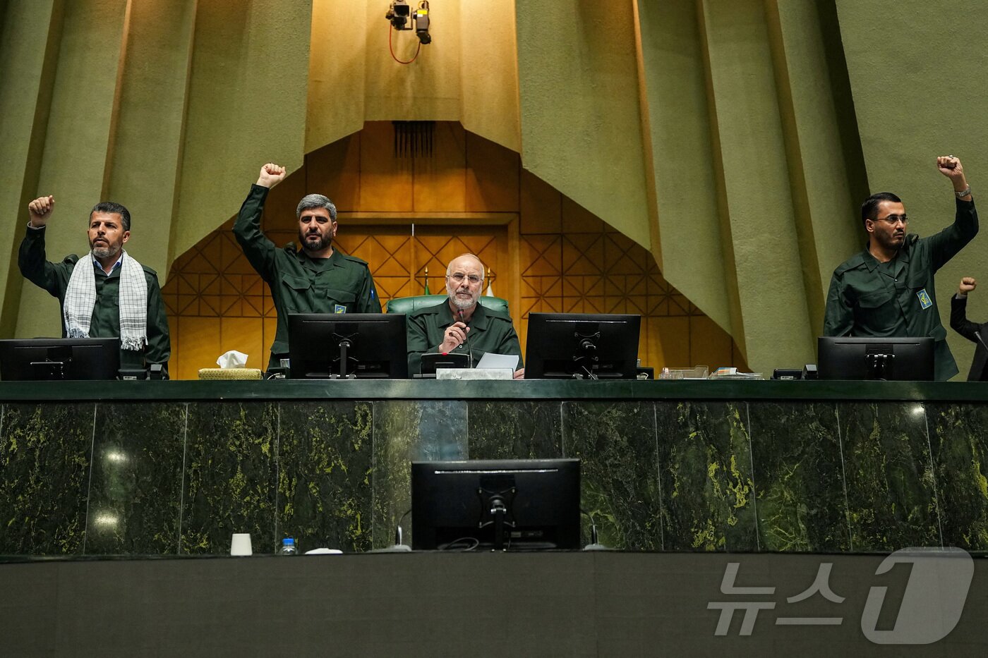 본문 이미지 - 1일(현지시간) 이란 테헤란에서 이란 국회의장 모하마드 바게르 갈리바프가 군복을 입고 이란 이슬람혁명수비대(IRGC)를 지지하는 구호를 외치는 의원들을 지켜보고 있다. 2026.02.01. ⓒ 로이터=뉴스1