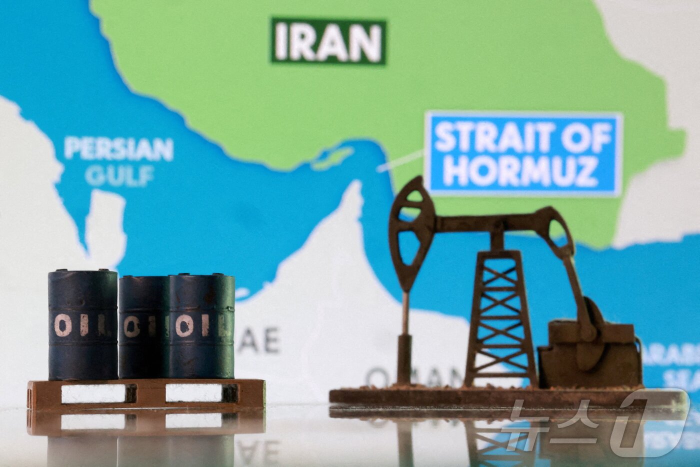 본문 이미지 - 호르무즈 해협과 이란의 지도 앞에 3D 프린터로 제작한 원유 시설과 원유 배럴 모형이 놓여 있다. (자료사진) 2026.3.3 ⓒ 로이터=뉴스1