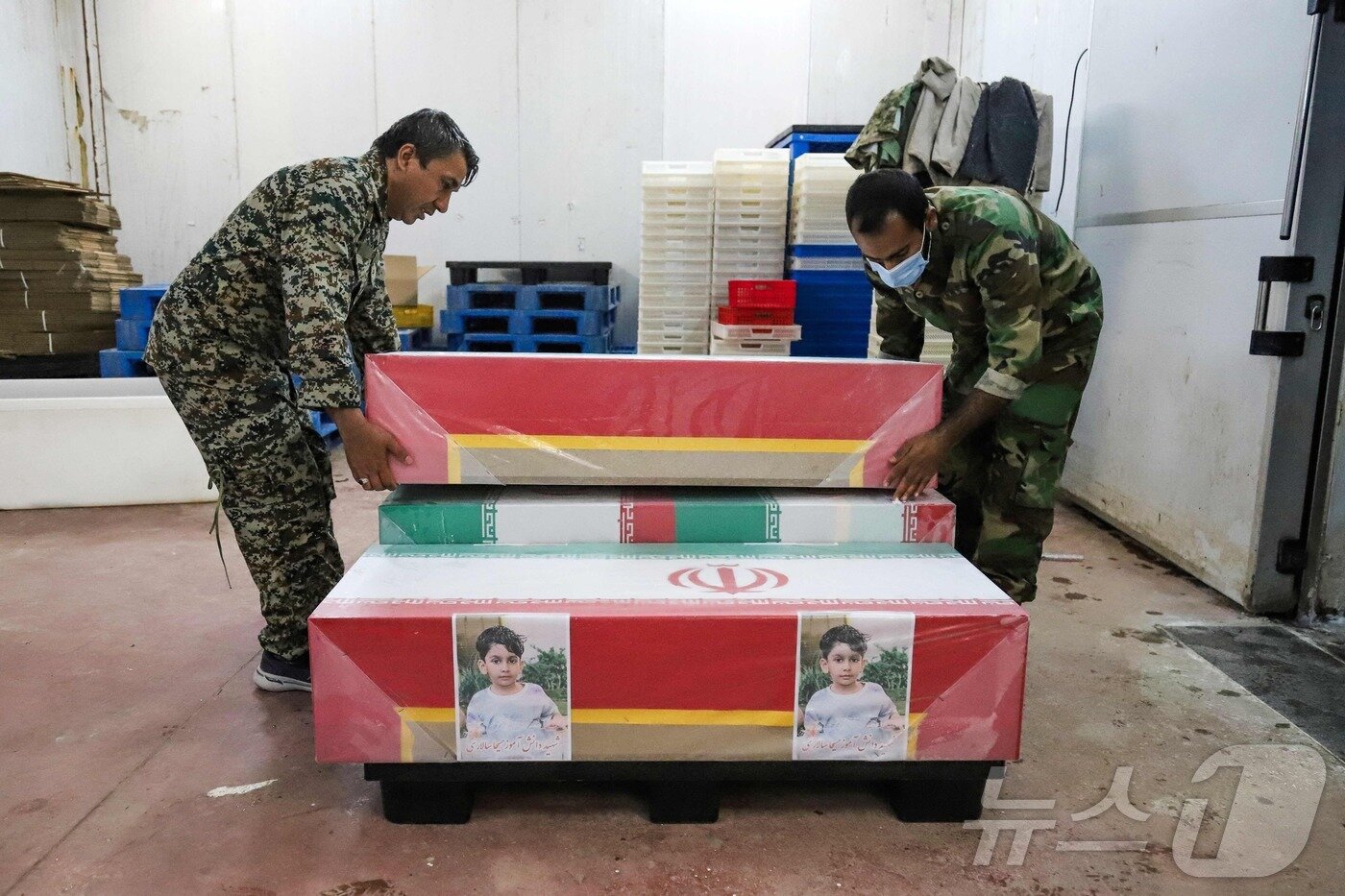 본문 이미지 - 3일(현지시간) 이란 호르모즈간 주 미나브에서 열린 초등학교 공습으로 사망한 어린이들의 장례식을 위해 조문객들이 관을 준비하고 있다. ⓒ AFP=뉴스1