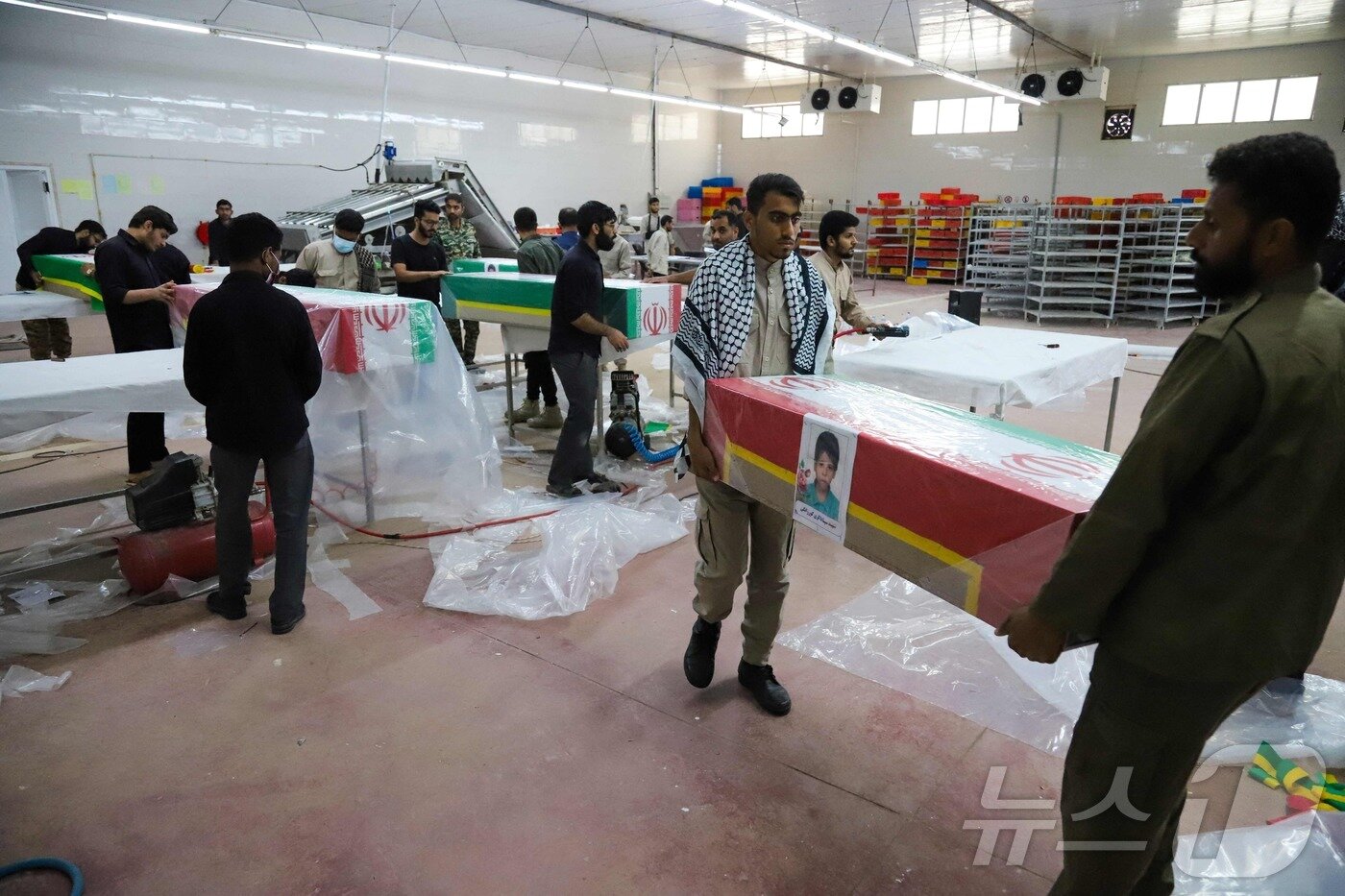 본문 이미지 - 3일(현지시간) 이란 호르모즈간 주 미나브에서 열린 초등학교 공습으로 사망한 어린이들의 장례식에서 조문객들이 관을 준비하고 있다. ⓒ AFP=뉴스1