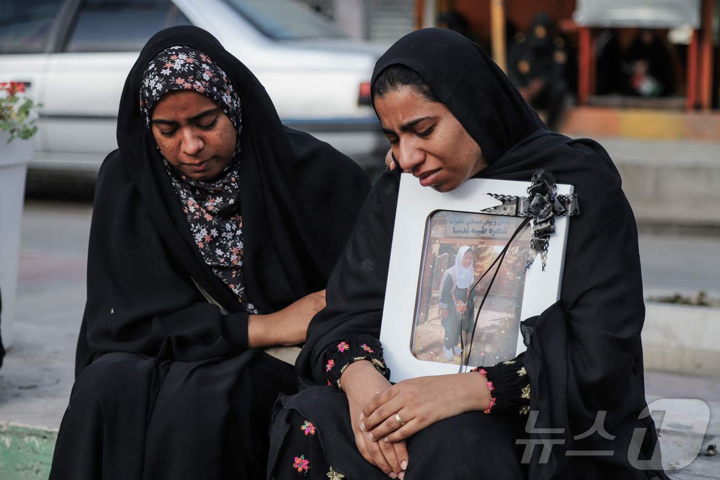 본문 이미지 -  3일(현지시간) 이란 호르모즈간 주 미나브의 한 초등학교에서 발생한 공습으로 사망한 어린이들의 장례식에 유가족들이 어린이의 영정사진을 들고 참석하고 있다. ⓒ AFP=뉴스1