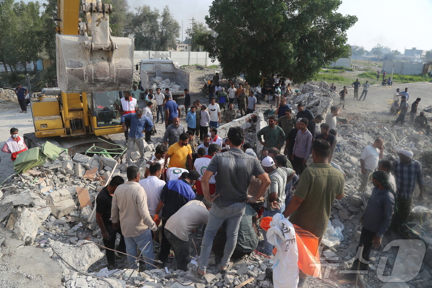 본문 이미지 - 지난달 28일(현지시간) 이란 남부 호르모즈간주 미나브 여자 초등학교 폭격 현장에서 구조대와 주민들이 부상자를 구조하고 있다.  ⓒ 신화=뉴스1