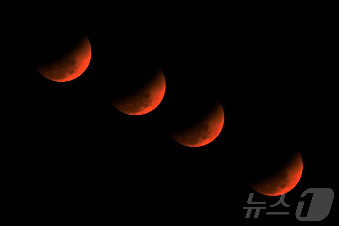 본문 이미지 - 3일 인도 아삼 골라가트에서 개기월식이 진행돼 붉은달이 보이고 있다.  ⓒ AFP=뉴스1