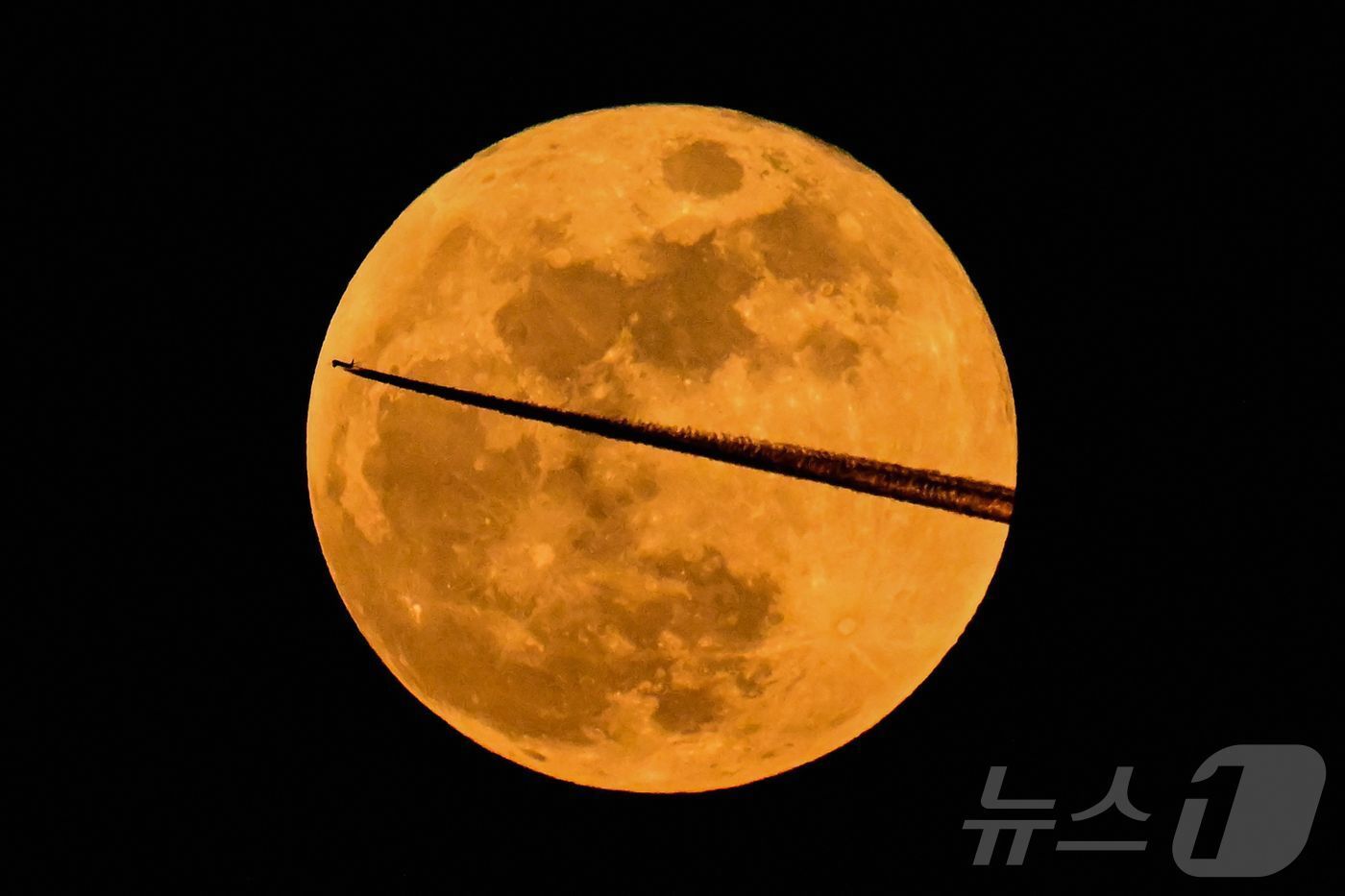 본문 이미지 - 3일 독일 프랑크푸르트 암 마인 상공에서 항공기가 보름달을 지나쳐 비행하고 있다. ⓒ AFP=뉴스1