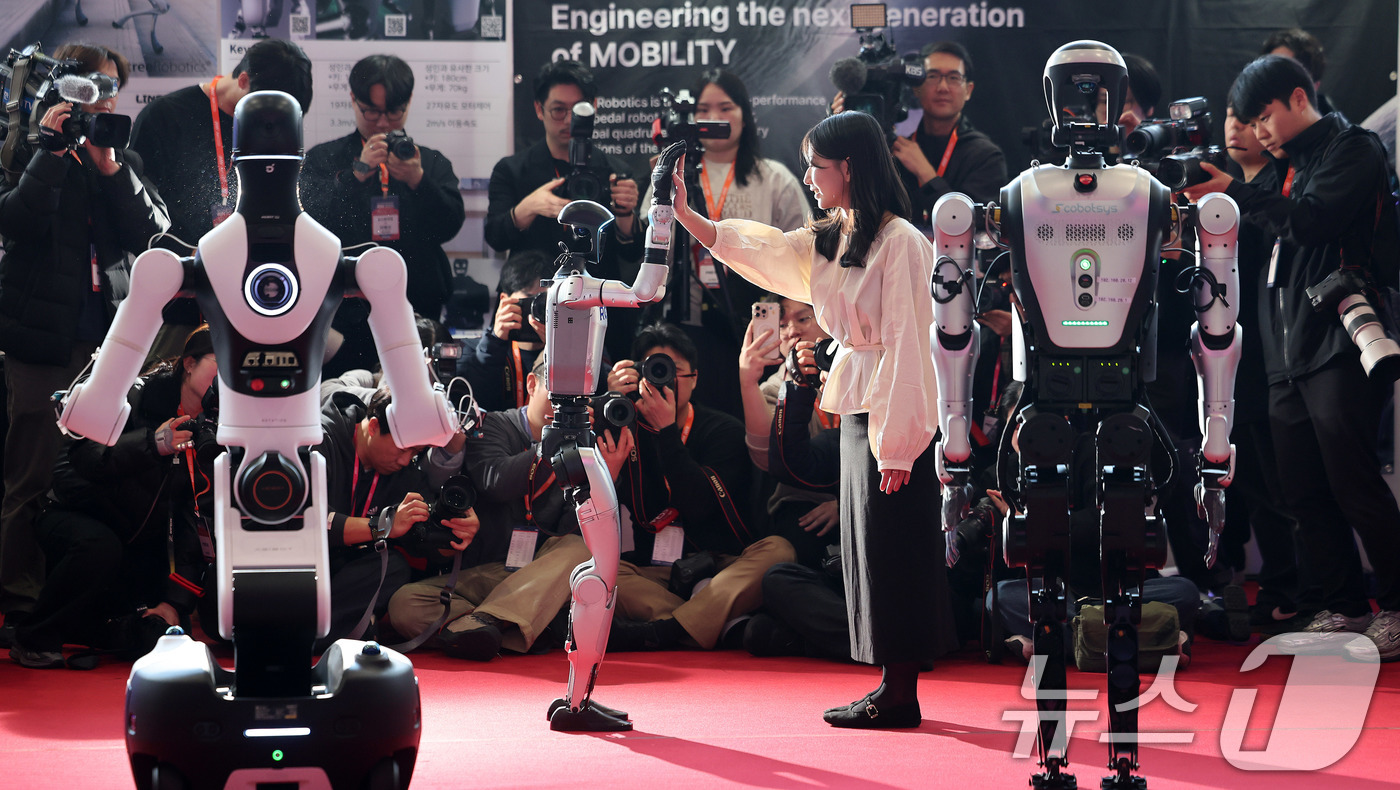 (서울=뉴스1) 박지혜 기자 = 4일 서울 강남구 코엑스에서 열린 ‘2026 스마트공장·자동화산업전(AW 2026)’에서 참관객이 중국 휴머노이드 로봇 유니트리의 G1과 인사를 나 …