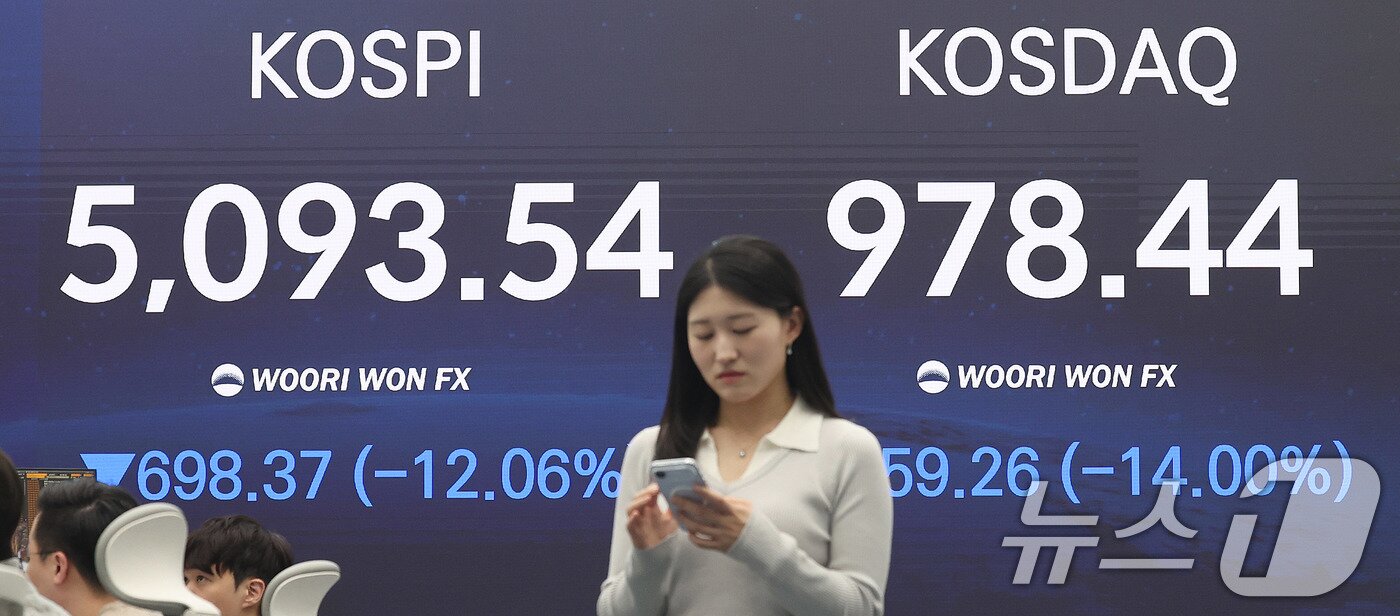 본문 이미지 - 코스피지수가 12% 넘게 폭락한 4일 오후 서울 중구 우리은행 본점 딜링룸 전광판에 코스피 종가가 표시되고 있다.  2026.3.4 ⓒ 뉴스1 박지혜 기자