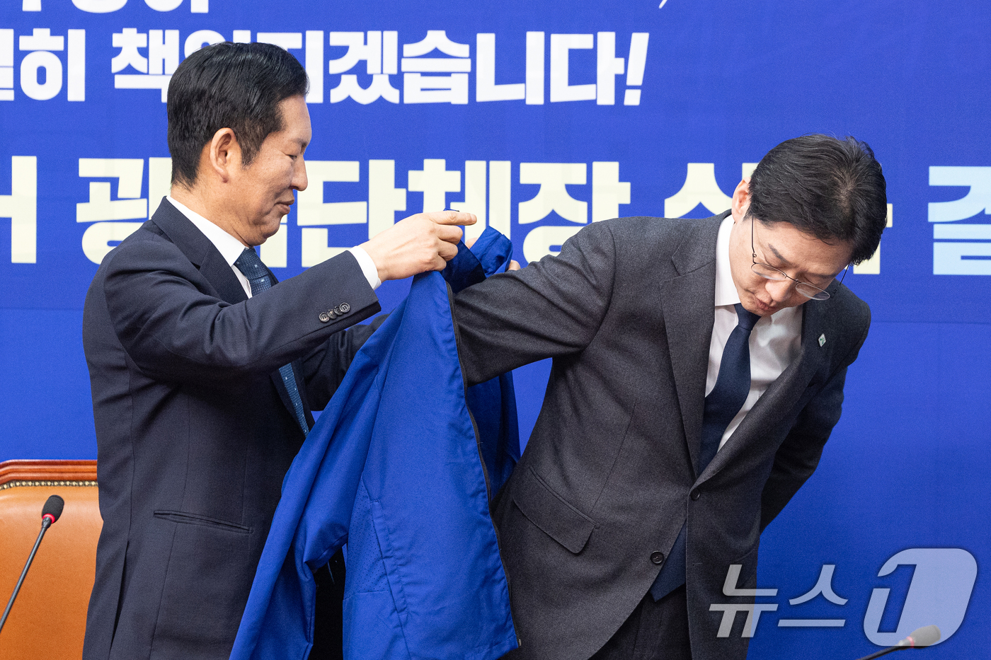 (서울=뉴스1) 이승배 기자 = 5일 서울 여의도 국회에서 열린 더불어민주당 공천 심사 결과 발표에서 정청래 대표가 경남지사 후보로 단수 공천된 김경수 지방시대위원장에게 점퍼를 입 …