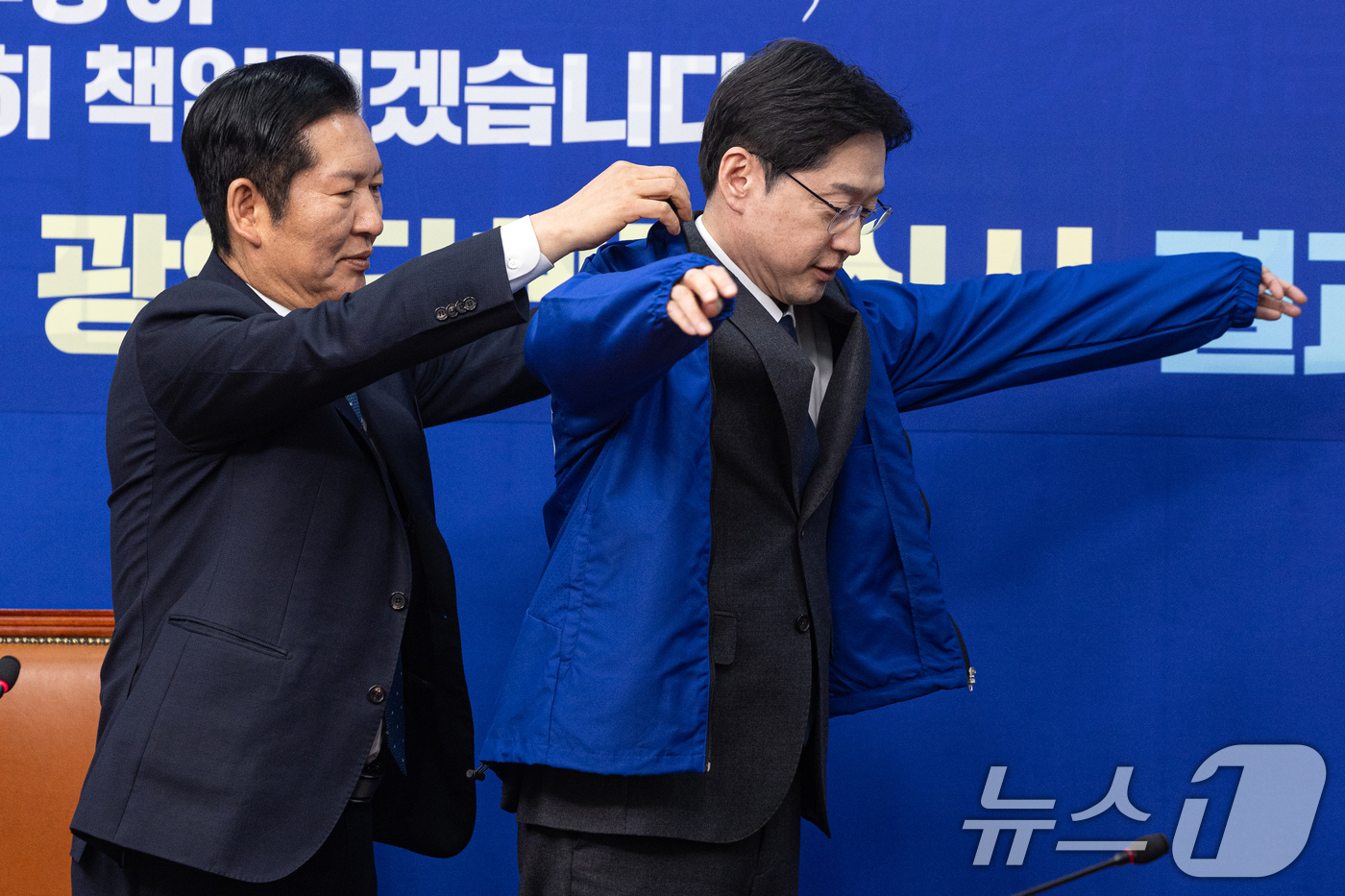 (서울=뉴스1) 이승배 기자 = 5일 서울 여의도 국회에서 열린 더불어민주당 공천 심사 결과 발표에서 정청래 대표가 김경수 지방시대위원장에게 점퍼를 입혀주고 있다.더불어민주당은 6 …